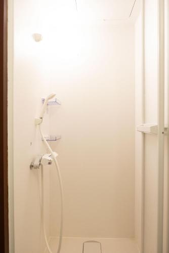 a shower with a shower head in a bathroom at Guest House KITOEDA in Nikko