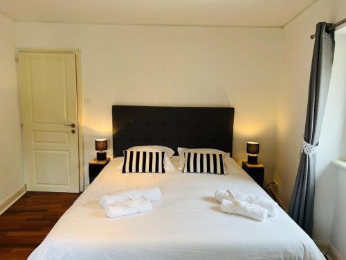 a bedroom with a large white bed with towels on it at Ty Kéréon - Le cocon urbain in Quimper
