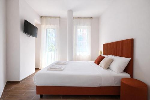 ein Schlafzimmer mit einem großen Bett und einem Fernseher an der Wand in der Unterkunft Maison Hermes in Mailand