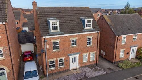 an aerial view of a brick building with a parking lot at Spacious 5-Bed Detached House, Sleeps 10, Parking in Desborough