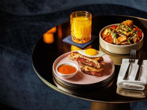 a table with a plate of food and a glass of beer at Fairmont Royal York Hotel in Toronto