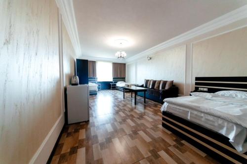 una camera da letto con un letto e un soggiorno di Garun Hotel a Gyumri