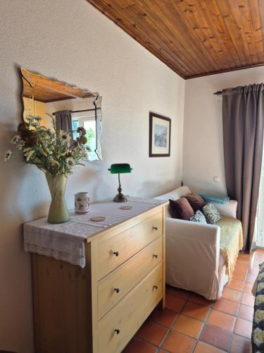 a bedroom with a dresser with a vase on it at Apartamento Charmoso no Funchal, com grande Jardim e Vista Esplêndida in Funchal