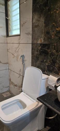 a bathroom with a toilet and a sink at Amrutvel Resort in Pune