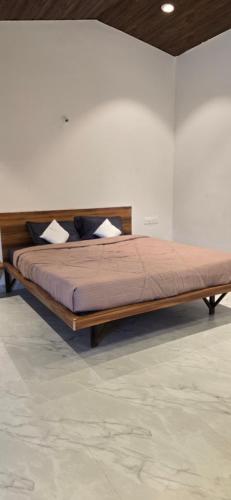 a large bed in a white room with at Amrutvel Resort in Pune