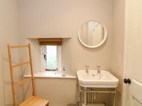 a bathroom with a sink and a mirror at School House in Ivybridge