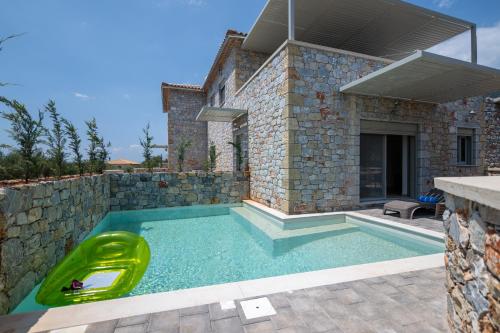 a swimming pool with a yellow plastic raft in front of a house at Pasithea Villas in Neokhórion