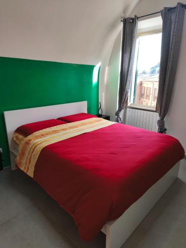 a bedroom with a red bed with a green headboard at Agli Archi Eco House in Chieti
