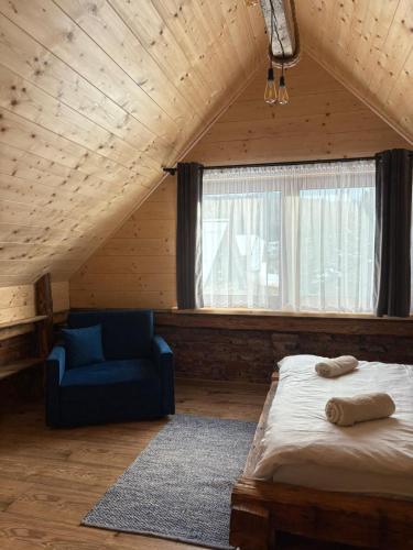a bedroom with a bed and a blue couch at Przystanek Stodoła in Rajcza