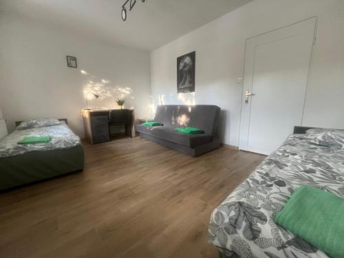 a living room with two beds and a couch at Pokoje Metro Imielin in Warsaw