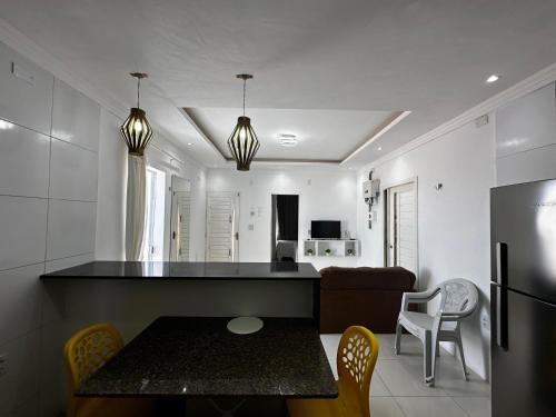 a kitchen and living room with a table and a refrigerator at AP Brisa do Rio in Galinhos