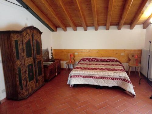 a bedroom with a large bed and a wooden cabinet at Locazione da nonna Gusta in Vittorio Veneto