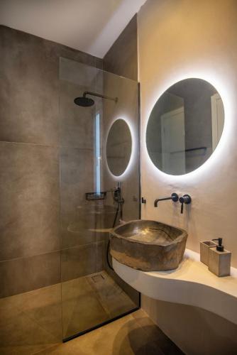 a bathroom with a stone sink and a shower at KYAN Syros in Liaropá