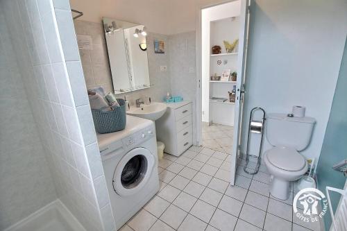 a white bathroom with a washing machine in it at Brin de bonheur in Évran