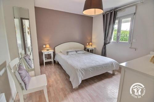 a bedroom with a bed and two tables and a window at Brin de bonheur in Évran