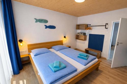 a bedroom with a bed with blue towels on it at Ankerix & Deichfix in Büsum
