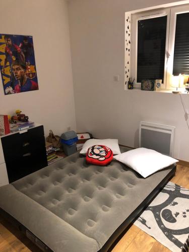 a bedroom with a bed with a red helmet on it at Chambre proche Colmar in Sainte-Croix-en-Plaine