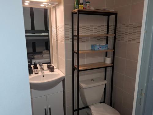 une salle de bains avec lavabo, toilettes et miroir dans l'établissement YUCCA, au Lavandou