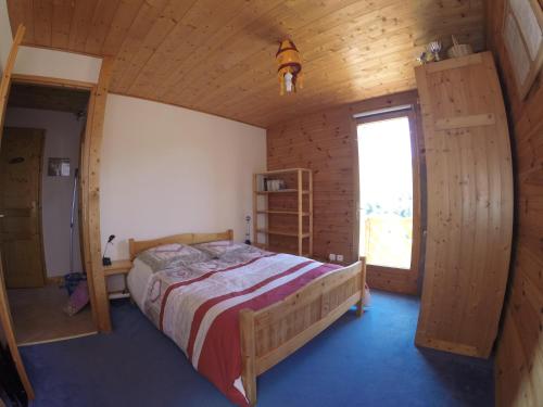 een slaapkamer met een bed in een houten huis bij Gite Le Croé in La Celle-sous-Gouzon