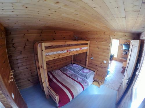 een slaapkamer in een blokhut met een stapelbed bij Gite Le Croé in La Celle-sous-Gouzon