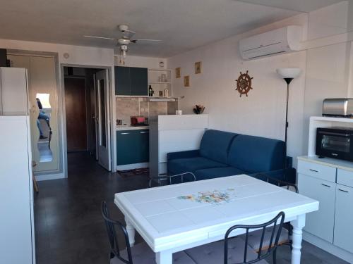 un salon avec un canapé bleu et une table dans l'établissement YUCCA, au Lavandou