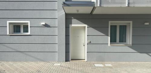 a building with a white door and two windows at Lupicante 56 Cesenatico in Cesenatico