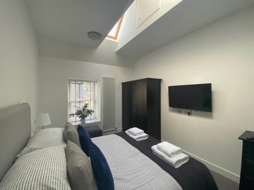 een slaapkamer met een bed en een flatscreen-tv bij The Loft in Anstruther