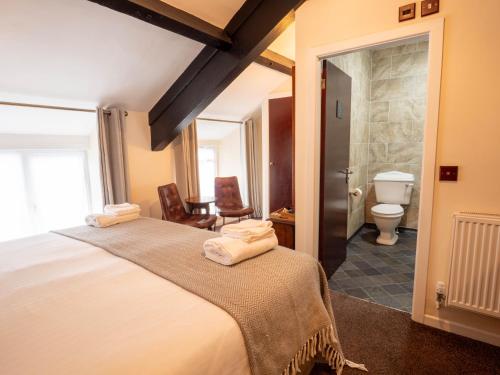 een slaapkamer met een bed en een badkamer met een toilet bij The Black Boy Inn in Caernarfon
