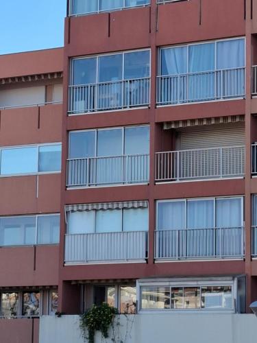 un immeuble d'appartements avec des balcons sur le côté dans l'établissement YUCCA, au Lavandou