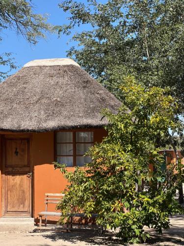 een kleine hut met een rieten dak en een bank bij Edsam Lodge in Divundu