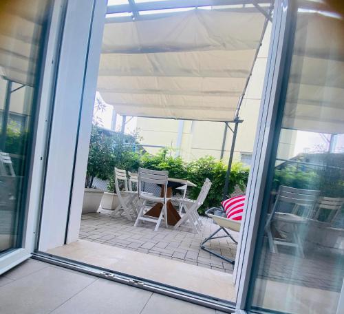 an open patio door with chairs and a table at Lupicante 56 Cesenatico in Cesenatico