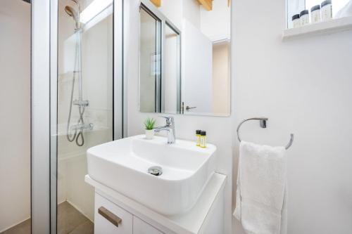 a white bathroom with a sink and a shower at Olga Premium Apartments in Limassol