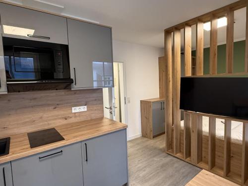 een keuken met een magnetron en een grote televisie bij Schmidteinander in Norderney