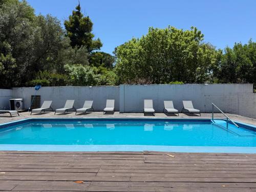 een zwembad met stoelen en een hek bij Hotel American in Piriápolis