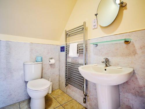 a bathroom with a sink and a toilet and a mirror at Hazel Lodge in Blairgowrie