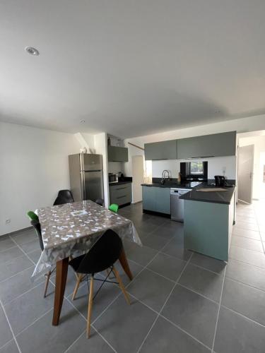 a kitchen with a table and some chairs in a room at La Flore in Baraqueville