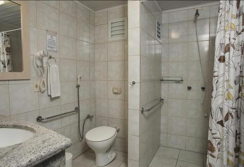 a bathroom with a shower and a toilet and a sink at Vila Olaria Hotel in Penha