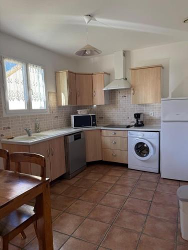 a kitchen with wooden cabinets and a white appliance at Villa T3 avec piscine in Sollacaro