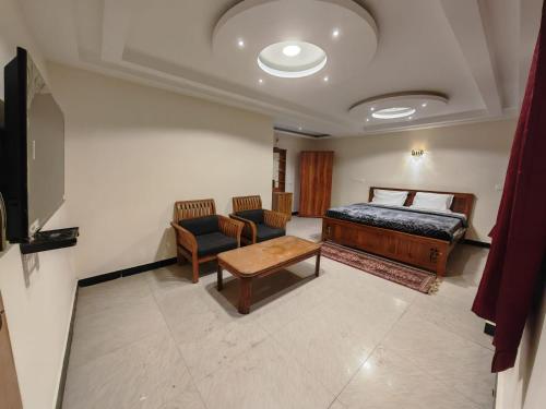 una camera da letto con un letto, un divano e un tavolo di The Hill Bunk Heights Ooty a Ooty