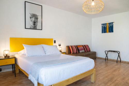 a bedroom with a large bed and a couch at qema Arequipa in Arequipa