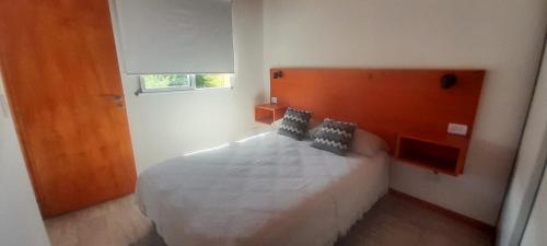 een slaapkamer met een groot wit bed en een raam bij cabañas sunrise in Merlo