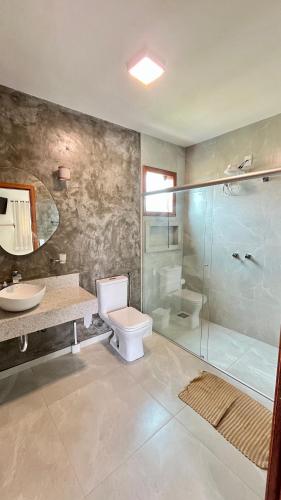 a bathroom with a shower and a toilet and a sink at Chalé M in Serra do Cipo