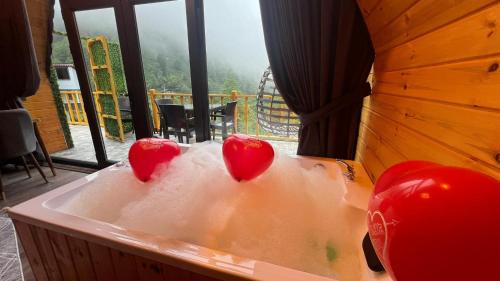 two red hearts sitting in a bath tub at AĞARaN SUİT BUNGALOV in Rize