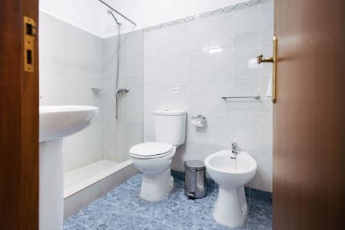 un bagno bianco con un water e un lavandino di MURÇAS 74 - STUDIO APARTMENTS a Funchal