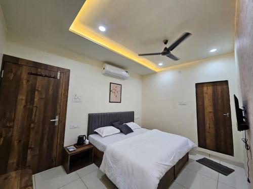 een slaapkamer met een bed en een plafondventilator bij Ikigai Stay 3BHK Duplex in Ujjain