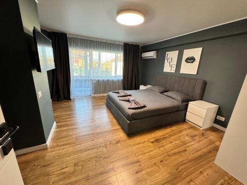 a bedroom with a bed and a wooden floor at V apartament - ultra central Otopeni in Otopeni