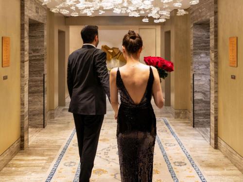 Un uomo e una donna che camminano lungo un corridoio di Raffles Istanbul a Istanbul