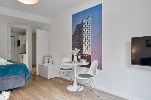 a bedroom with a bed and a table and chairs at Ankerherz Appartements bei Blankenese in Hamburg