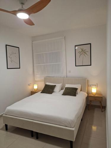 a bedroom with a large white bed with two lamps at Histadrout street 3 bedrooms central Ashdod in Ashdod