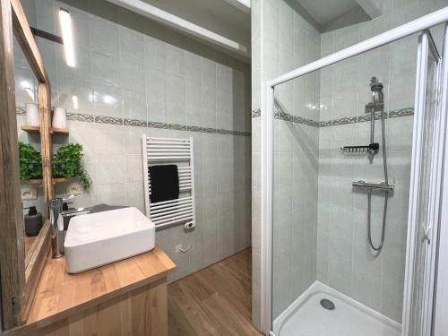 een witte badkamer met een wastafel en een douche bij La Maison Bonheur - Authentique et Centrale in Cerizay